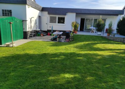 Großer Garten hinter dem Bungalow mit Rasenfläche, Spielbereich und Terrasse – kinderfreundlich und vielseitig nutzbar